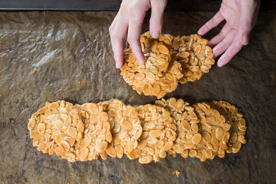 Human hands making Almond Tuiles