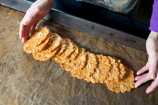 Human hands making Almond Tuiles
