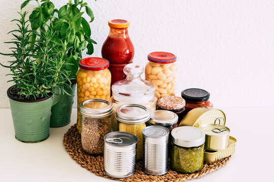 Covid-19 coronavirus infection. Small pantry of food for the period of self-isolation in quarantine. Several glass jars with cereals, legumes, jams, pasta and rice, canned cans