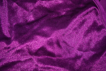 Fototapeta na wymiar Bright colorful, rich velvet purple background with overflow and ebb. An unusual shaggy purple fabric with curves and waves is located on a flat surface, an unusual look.