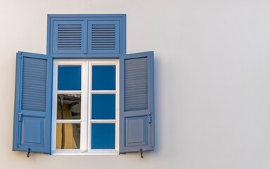 Fototapeta premium vintage blue shutters with white frame window, space for text