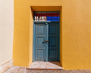 painted wooden external door and colorful wall by the sidewalk, Athens Greece. Space for text