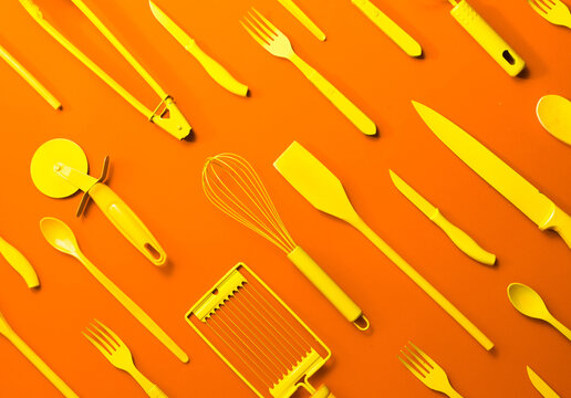 Well organised yellow kitchen objects on orange background.