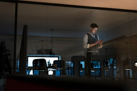 Young businessman using a phone in office