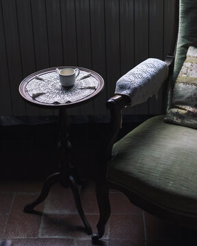 Vintage armchair and coffee table with empty cup