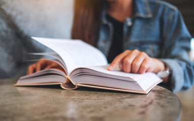 Closeup image of a young woman sitting and reading book
