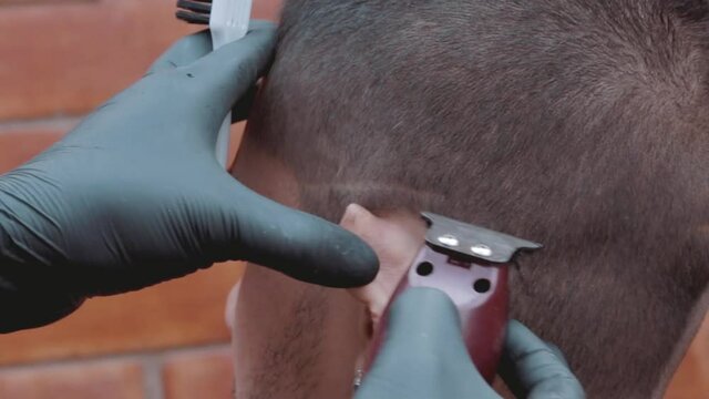 Barbero marcando cr&aacute;neo de modelo masculino antes de afeitar con navaja en barber shop