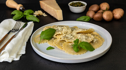Cooked ravioli or tortelli with cheese, basil, and mushrooms.