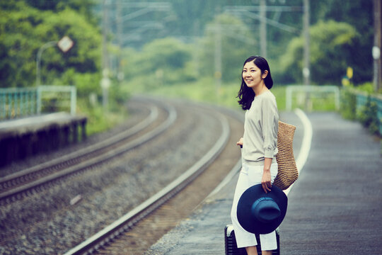 駅のホームに立つ女性