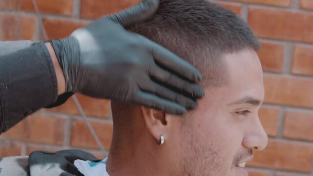 Barbero usando gel para afeitar a modelo masculino en barber&iacute;a o barber shop
