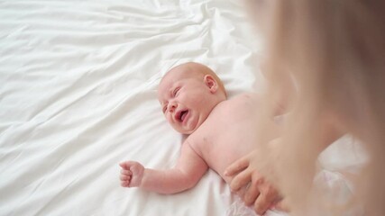 mom changes baby's diaper and takes it in arms to calm it down. newborn care.