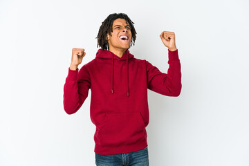 Young african american rasta man raising fist after a victory, winner concept.