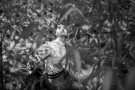 Black and white portrait of a mysterious young woman looking up in a bamboo grove