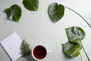 green leaves, a cup of herbal black tea as working or studying concept. minimalism. 