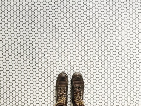 Woman standing on patterned white and black hexagon tile floor