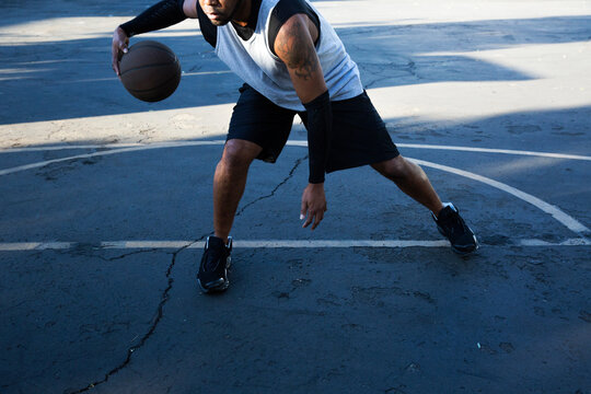 Man playing basketball on outside court