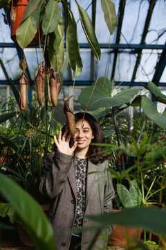 Woman laughs while touching phallic pitcher plants.