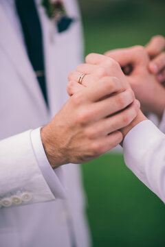 Bride and Groom holding hands showing their wedding rings