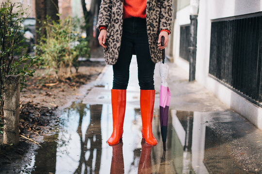 Stylish woman standing in the puddle