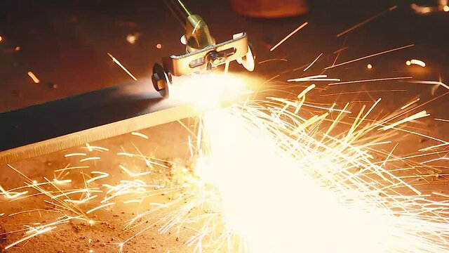 Factory worker cutting metal using acetylene torch, manual plasma cuting in a steel factory lot's of sparks all over