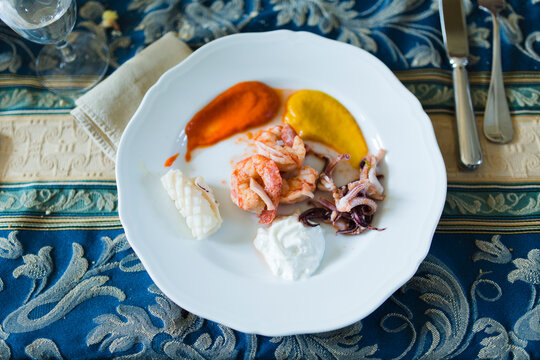 Cooked calamari, prawns and mozzarella cheese on dish with vegetable dressings