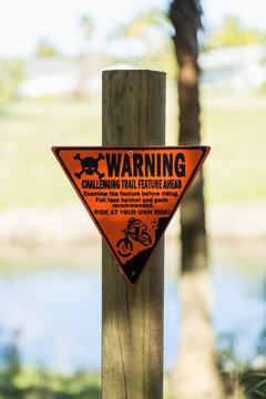 Warning sign on the side of a mountain biking trail