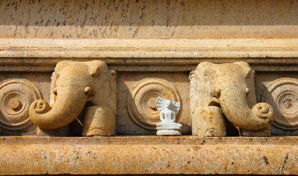 Beautiful architecture detail - little white Buddha figurine on the ancient bas relief with elephants, sacret Ruwanmalisaya Dagoba, Anuradhapura, Sri Lanka, South Asia