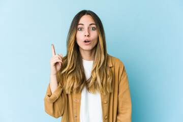 Young caucasian woman isolated on blue background having an idea, inspiration concept.