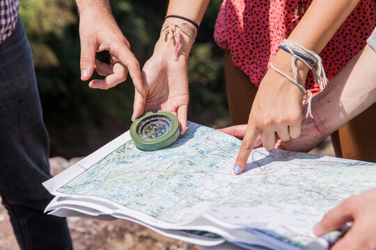 Group of friends looking at the map together and using compass