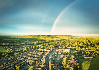 Aerial view of scenic English town with a rainbow and the Surrey Hills in the background