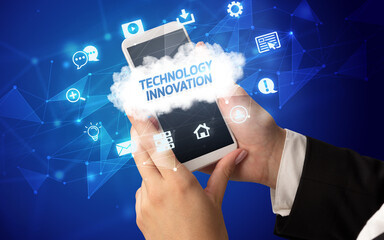 Female hand holding smartphone with TECHNOLOGY INNOVATION inscription, cloud technology concept