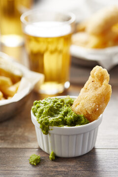 Piece of fried fish in mushy peas