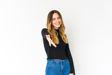 Young caucasian woman isolated on white background stretching hand at camera in greeting gesture.