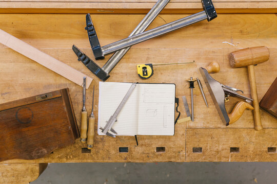 Topshot of a workbench with a design and tools on it