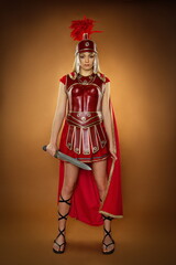 Naklejka premium Fashion studio shot of beautiful woman in armour and helmet