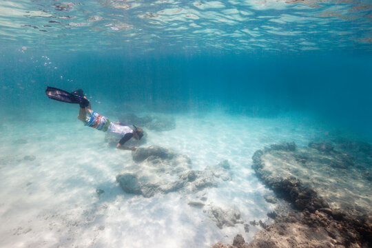 Young blond man snorkeling in tropical waters