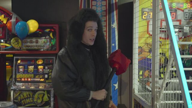 Man playing the King of the Hammer in an indoor arcade