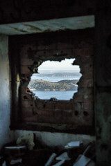 ventana de casa abandonada con vistas a la playa