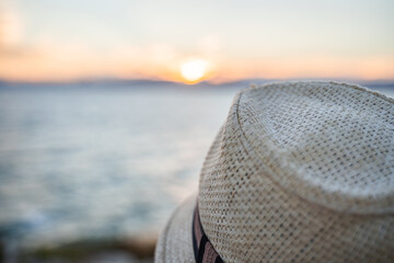 sombrero de playa con atardecer de fondo