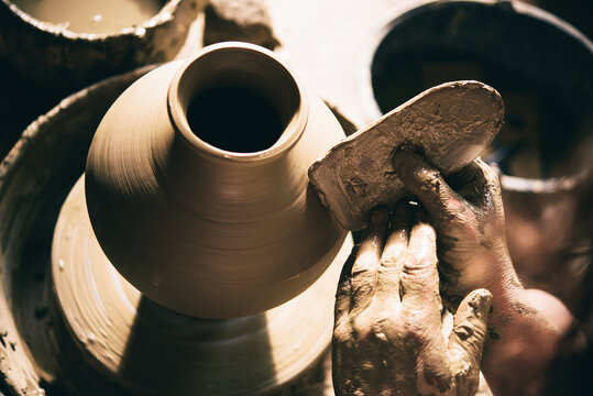 Close-up on potters hands making clay pottery