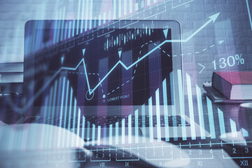 Forex market graph hologram and personal computer on background. Double exposure. Concept of investment.