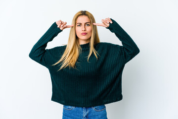 Young blonde woman isolated on white background focused on a task, keeping forefingers pointing head.