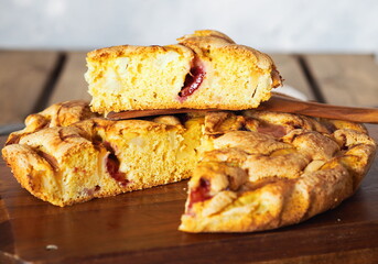 Apple summer seasonal charlotte pie with fresh apples and plums on a wooden kitchen board.Homemade cakes for tea.