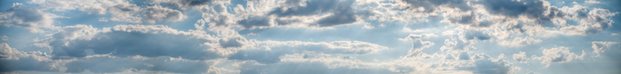 Panorama of blue sky with fluffy white clouds. Abstract background.