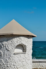 Fototapeta premium Minimalist aesthetics. Minimal detail of architecture against the sky and sea. White clay house, summer photo