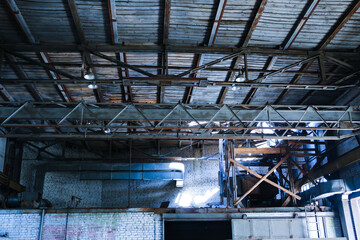 old, abandoned factory. Scattered glass, iron, wooden remains of the production on the floor, covered with snow and sawdust. Broken pipes, broken wiring, signal lights, broken roof and crane girder.