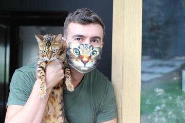 Man wearing protective mask with print of his cat&acute;s face 
