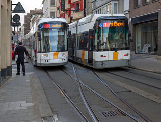 Fototapeta na wymiar Ghent, Belgium: two trams block one of the narrow streets, Nederkouter, in the city centre.