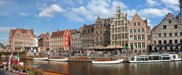 Naklejka premium Ghent, Belgium: panoramic view on canal boats and many visitors at Graslei and Korenlei, famous for their historic facades.