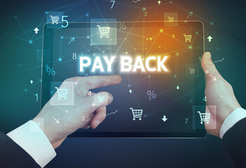 Close-up of a hand holding tablet with PAY BACK inscription, online shopping concept
